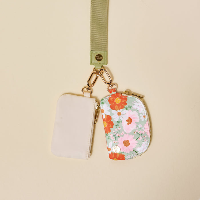 The-darling-effect’s Bouquet Beauty Sage Dynamic Duo Pouch Wristlet features a luxe lanyard with a gold clasp, holding two chic zippered pouches—one beige, one floral—for stylish hands-free carrying.