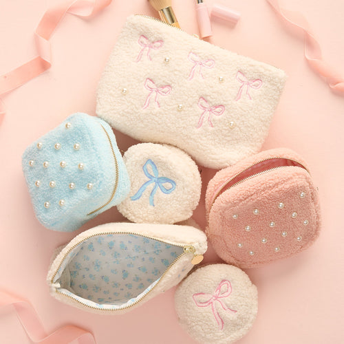 White textured zipper pouch with embroidered images of mushrooms, chanterelles, cherry tomatoes, orange slices, and the words la dolce vita in red script on the front.