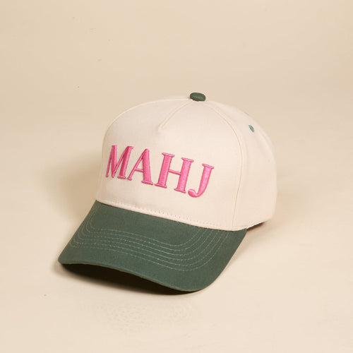 The Mahj Classic Canvas Hat by The Darling Effect features a beige canvas design with a dark green brim and button, "MAHJ" embroidered in large pink letters on the front, and offers a relaxed fit for stylish everyday wear.