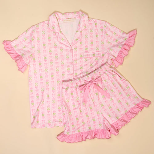 The Darling Effect's Oh So Fancy Pink Slumber Party Pajama Shorts Set features a satin-like, ultra-soft fabric, light pink floral pattern, ruffled edges, button-up top and matching shorts—perfect for relaxing nights.