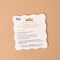 A scalloped-edge card on a tan background displays application instructions for The Darling Effect’s On Patch-Pumpkin Spice Season Mix & Match Iron patches, featuring colorful designs and outlining the steps to iron, peel, and cool, along with a warning about chemical exposure.