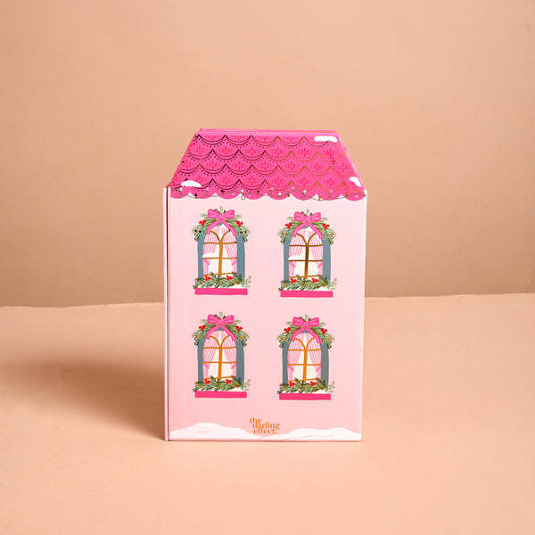 Pink house-shaped Adoring Ornaments Ornament Advent Calendar featuring four illustrated windows decorated with pink bows and greenery.