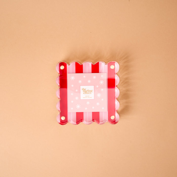Peppermint Stripes Little Moments Acrylic Picture Frame featuring a square shape with a scalloped edge, red and white stripes, and a pink snowflake-patterned insert.