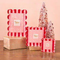 Three Peppermint Stripes Little Moments Acrylic Picture Frames with red and pink stripes and white snowflake accents, displayed next to two pink decorative Christmas trees on gold-wrapped boxes.