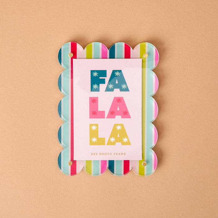Fa La La Mini Acrylic Picture Frame Magnet with a scalloped edge and colorful vertical stripes, holding a card that reads FA LA LA in block letters.