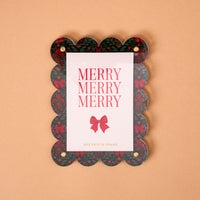 A Merry Moment Mini Acrylic Picture Frame Magnet with a scalloped edge, Christmas holly and red bow pattern, and a card reading Merry Merry Merry.