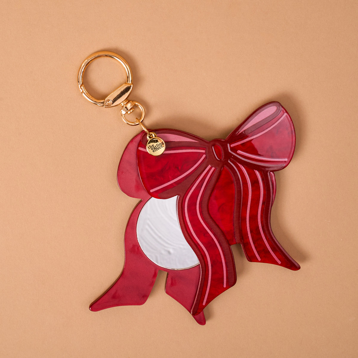 Red Bow Mini Mirror Bag Charm featuring a red acrylic bow-shaped mirror with a gold-toned clip.