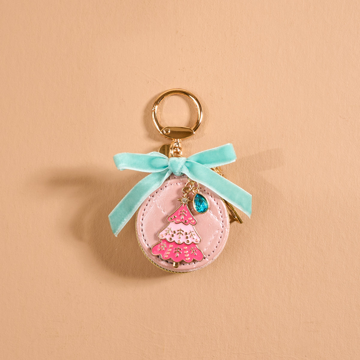 Frosted Pink Travel Jewelry Case Bag Charm shaped like a round pink case, featuring a pink Christmas tree, blue teardrop stone, light blue ribbon, and gold keychain ring.