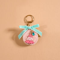 Frosted Pink Travel Jewelry Case Bag Charm shaped like a round pink case, featuring a pink Christmas tree, blue teardrop stone, light blue ribbon, and gold keychain ring.