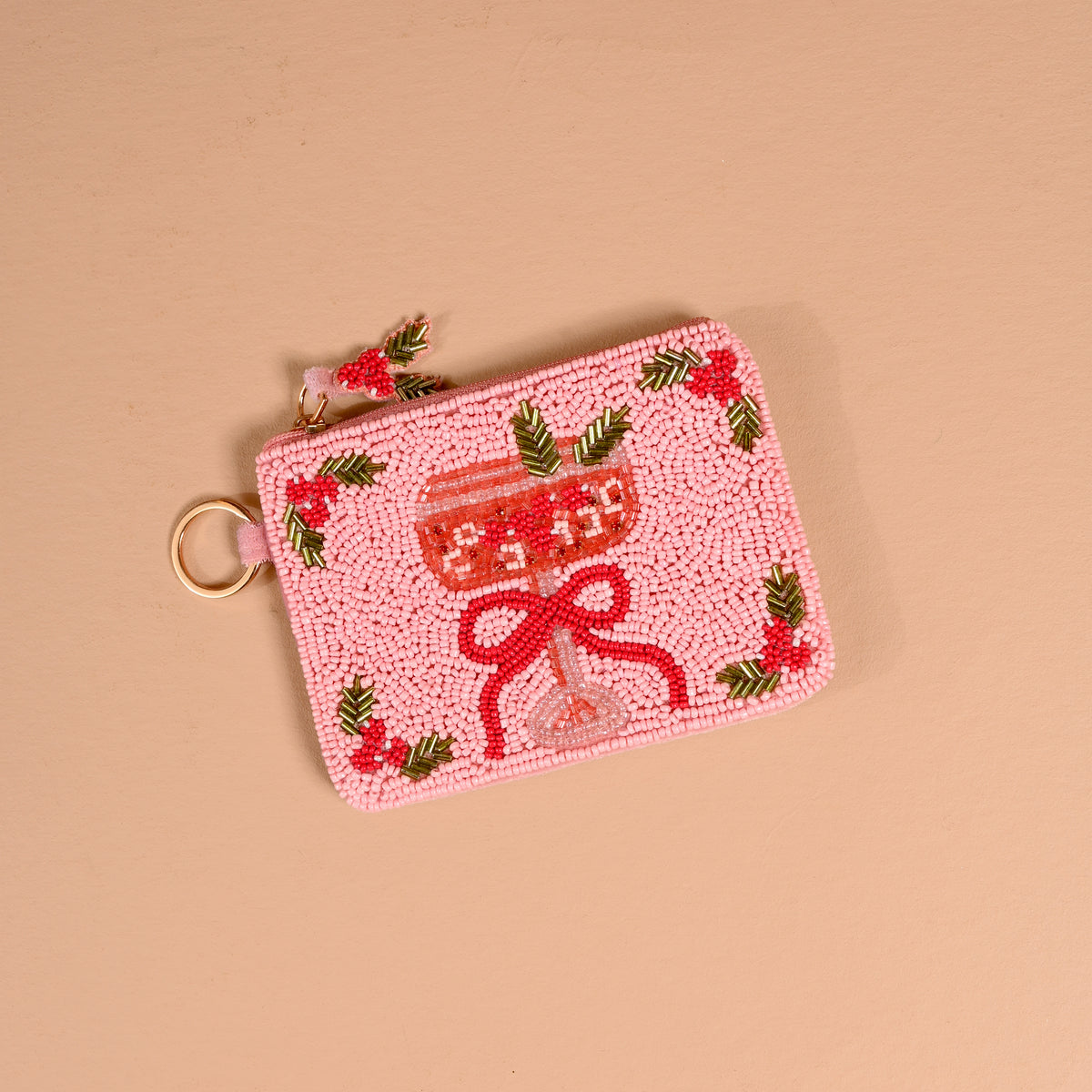 A light pink Cranberry Cosmo Handcrafted Beaded Pouch featuring a cocktail glass with a red bow and holly accents.
