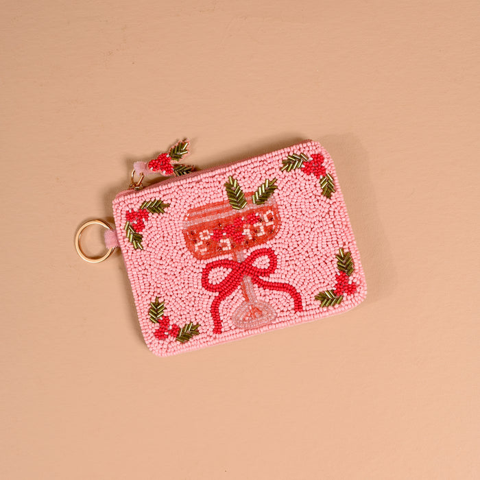 A light pink Cranberry Cosmo Handcrafted Beaded Pouch featuring a cocktail glass with a red bow and holly accents.