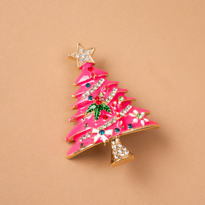 Whimsical Tree Timeless Brooch featuring a pink enameled Christmas tree decorated with colorful crystals, green holly leaves, and a star topper; a vintage-inspired keepsake accessory.