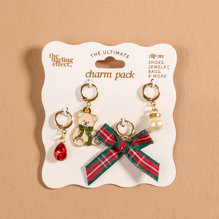 Comfort & Joy The Ultimate Charm Pack featuring four holiday-themed accessory charms on a display card, including a red gem, a teddy bear, a plaid bow, and a faux pearl.