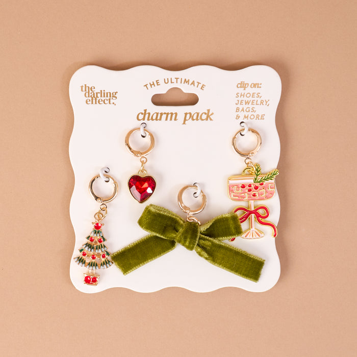 Feeling Festive The Ultimate Charm Pack featuring four gold-tone jewelry charms on a display card: a Christmas tree, a red heart, a green bow, and a cocktail glass.