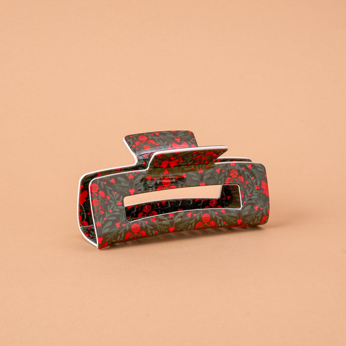 A Merry Moment Claw Clip featuring a rectangular design with a dark green floral and berry pattern for a strong hold.