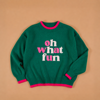 Oh What Fun Classic Sweater in green with pink trim on the collar, cuffs, and hem, featuring the words oh what fun embroidered in pink and white on the front for a festive layered style.