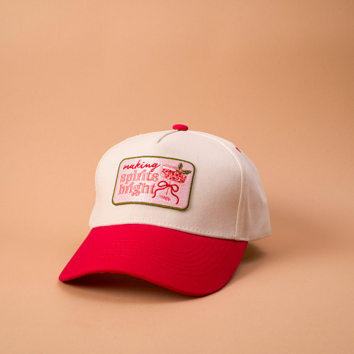 Making Spirits Bright Classic Canvas Hat in off-white with a red brim and a patch featuring a cocktail glass and the text making spirits bright.