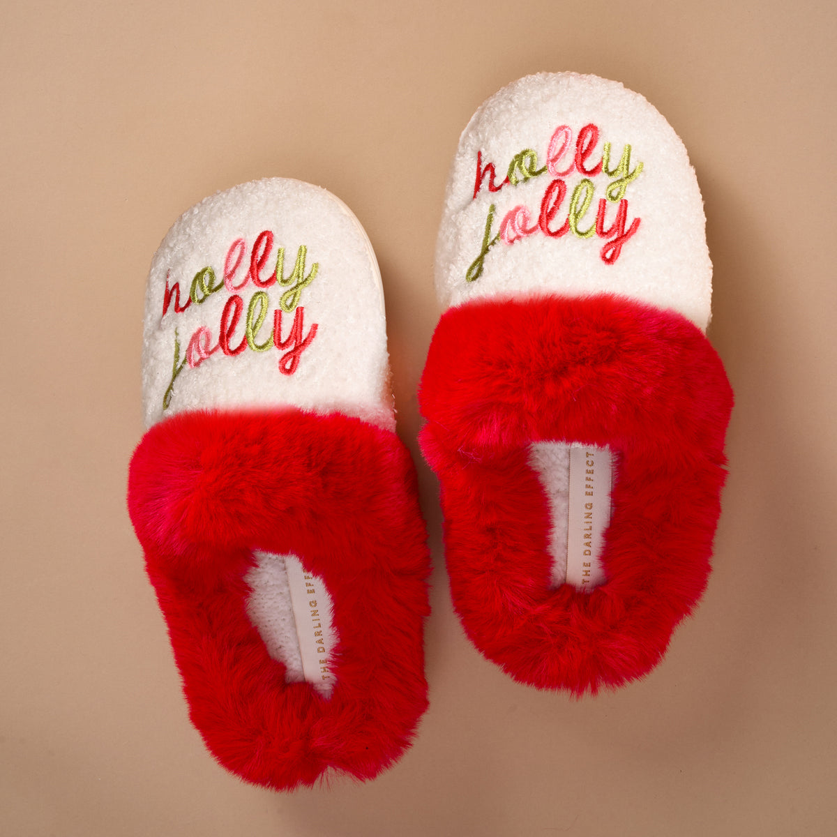 Holly Jolly Dreamy Daze Slippers with white faux-fur collars, red trim, and holly jolly embroidered in red and green thread on the toes.