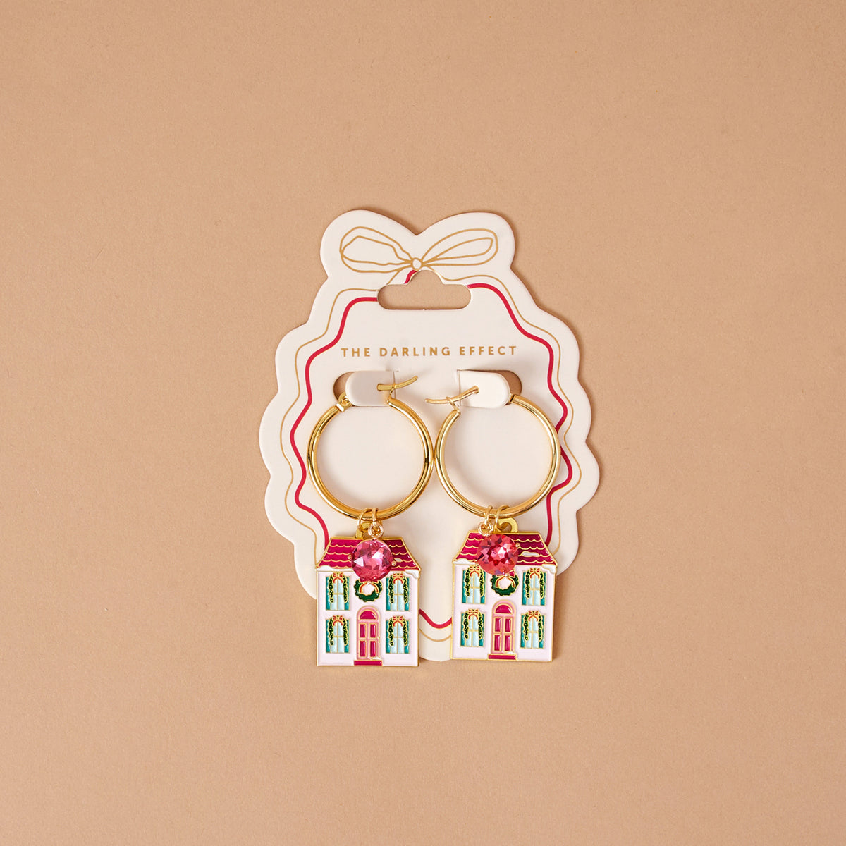 BowBelle Manor Signature Hoop Earrings, gold hoops featuring house-shaped pendants with pink rhinestone roofs and green decorative wreaths.