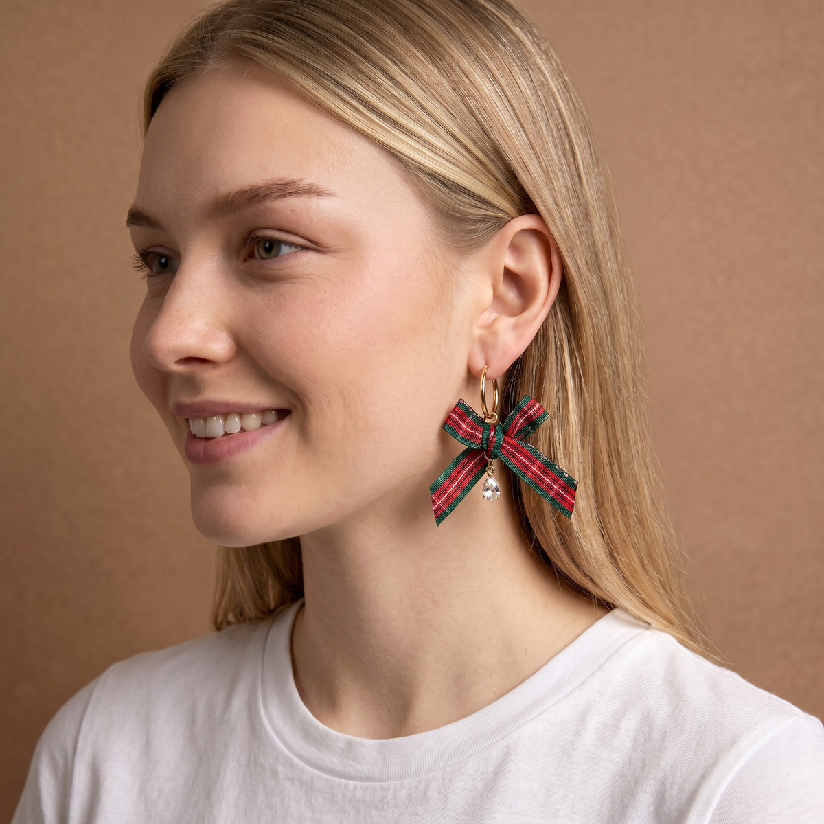 Dressed in Plaid Signature Hoop Earrings featuring a red and green plaid ribbon bow and a small dangling crystal charm, these lightweight gold hoops add a festive touch.