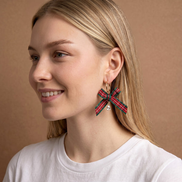 Dressed in Plaid Signature Hoop Earrings featuring a red and green plaid ribbon bow and a small dangling crystal charm, these lightweight gold hoops add a festive touch.