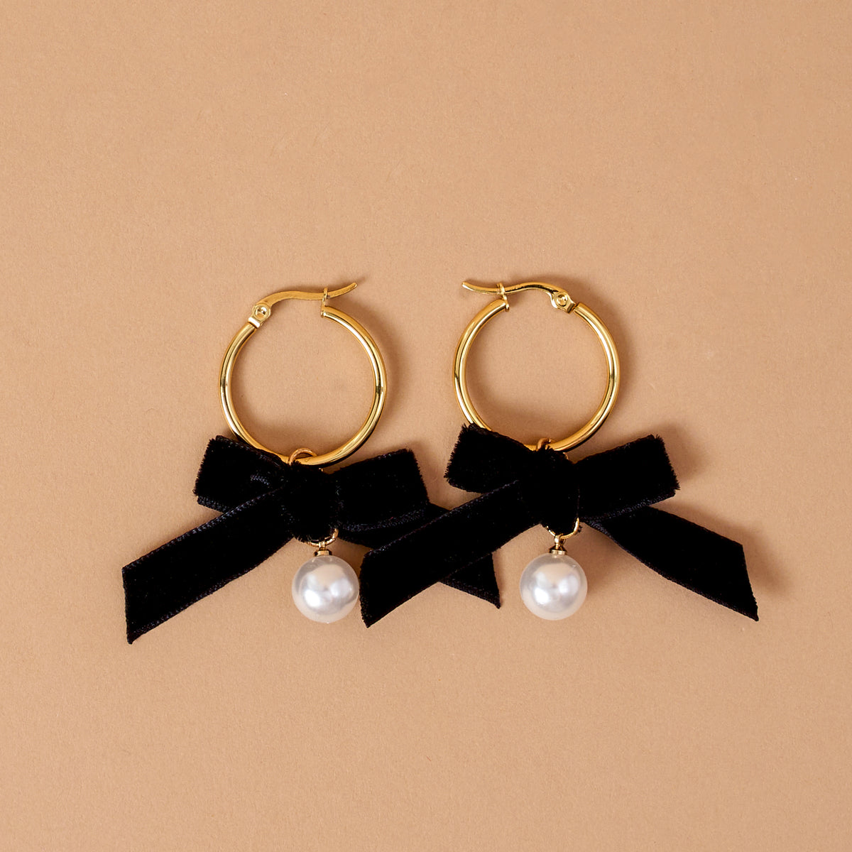 Midnight Velvet Signature Hoop Earrings featuring gold hoops, black ribbon bows, and single dangling white pearls.