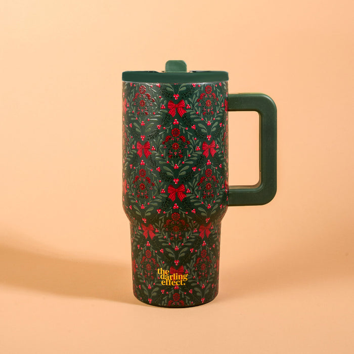 A Merry Moment 20 oz Lifestyle Flip Straw Tumbler in green with a handle, lid, and a repeating pattern of red bows, holly, and greenery.