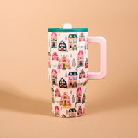 Sugarplum Lane 20 oz Lifestyle Flip Straw Tumbler featuring a tall, insulated stainless steel design with a handle, patterned with colorful Christmas houses and pine trees, and topped with a green lid and a flip straw.