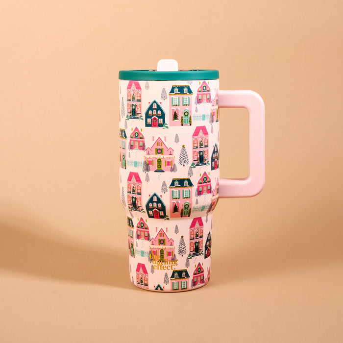 Sugarplum Lane 20 oz Lifestyle Flip Straw Tumbler featuring a tall, insulated stainless steel design with a handle, patterned with colorful Christmas houses and pine trees, and topped with a green lid and a flip straw.