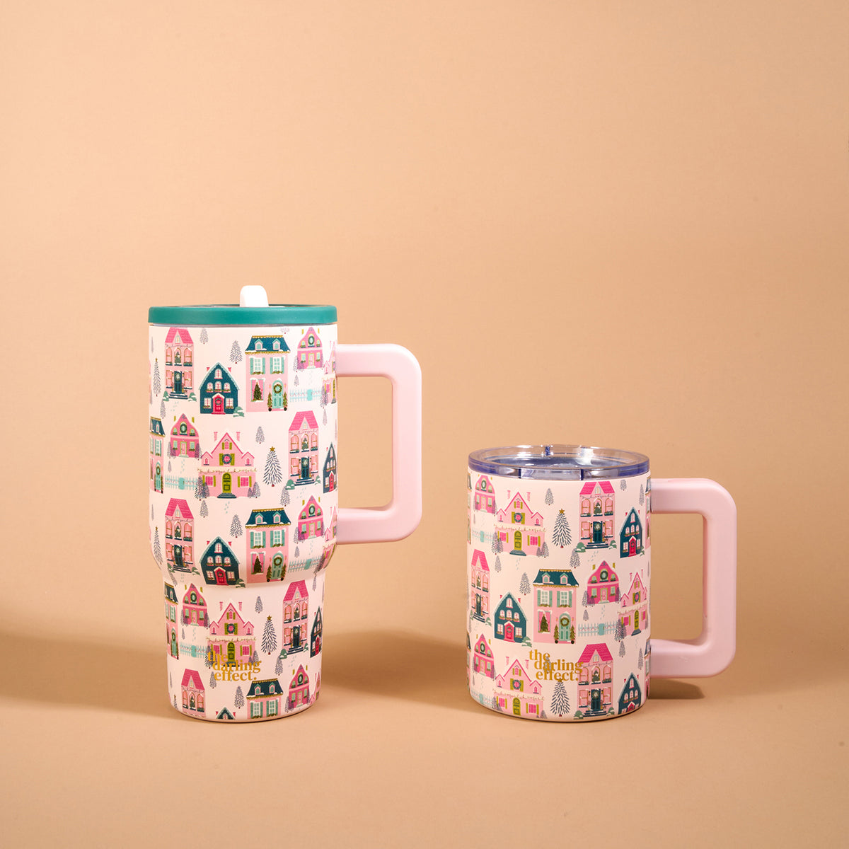 Two Sugarplum Lane 20 oz Lifestyle Flip Straw Tumblers with handles, featuring a repeating pattern of colorful houses and pine trees.