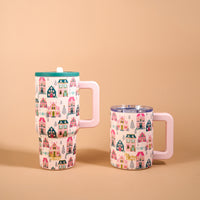Two Sugarplum Lane 20 oz Lifestyle Flip Straw Tumblers with handles, featuring a repeating pattern of colorful houses and pine trees.