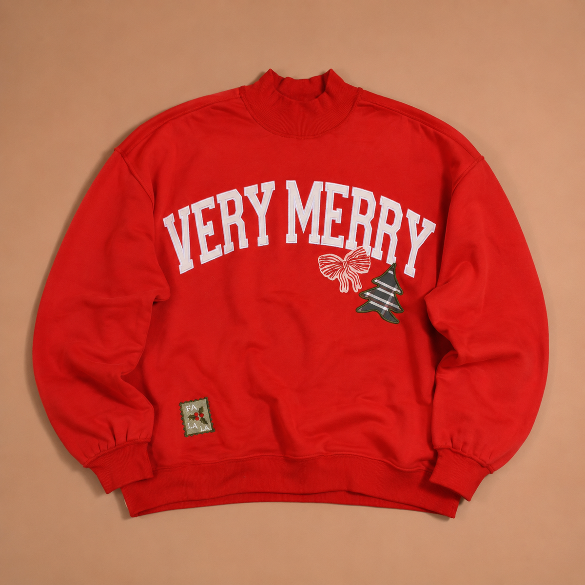 Red Vintage Very Merry Mockneck Sweatshirt with white VERY MERRY lettering, a bow, a patterned Christmas tree, and a FA LA LA patch.