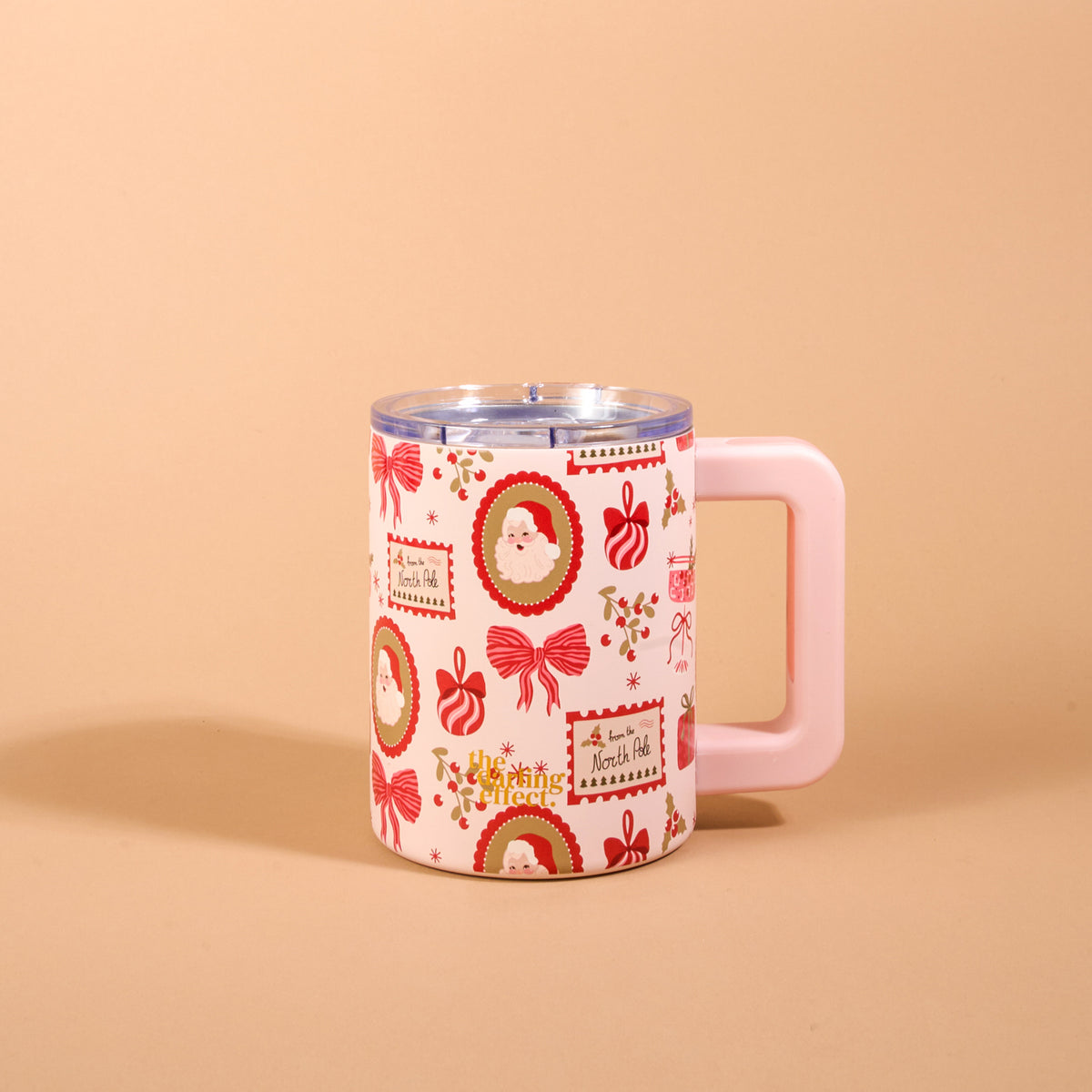 Mistletoe Magic 14 oz Insulated Mug featuring a double-wall design, a clear lid, a light pink rectangular handle, and a pattern of Santa Claus portraits, bows, and North Pole postal stamps in red and green.