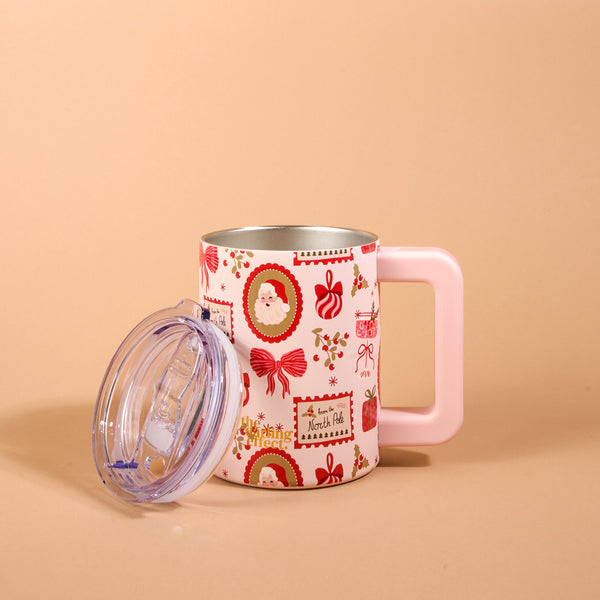 Mistletoe Magic 14 oz Insulated Mug featuring a pastel pink handle and a pattern of Christmas imagery including Santa, bows, and presents, shown with its clear lid resting beside it.