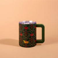A Merry Moment 14 oz Insulated Mug featuring a dark green floral holiday pattern with red berries and bows, a clear lid, and a solid green handle.