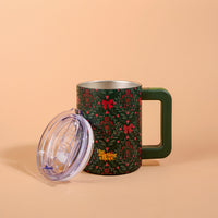 A Merry Moment 14 oz Insulated Mug in dark green with a holiday holly and red bow pattern, featuring a square handle and a clear plastic lid leaning against its side.