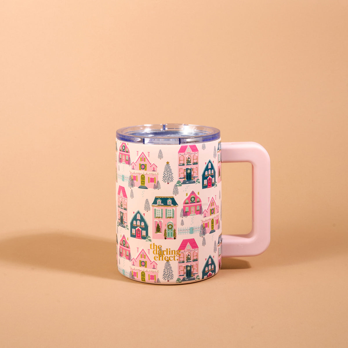 Sugarplum Lane 14 oz Insulated Mug featuring a repeating pattern of colorful holiday houses and pine trees, designed with a double-wall, a clear lid, and a light pink square handle.