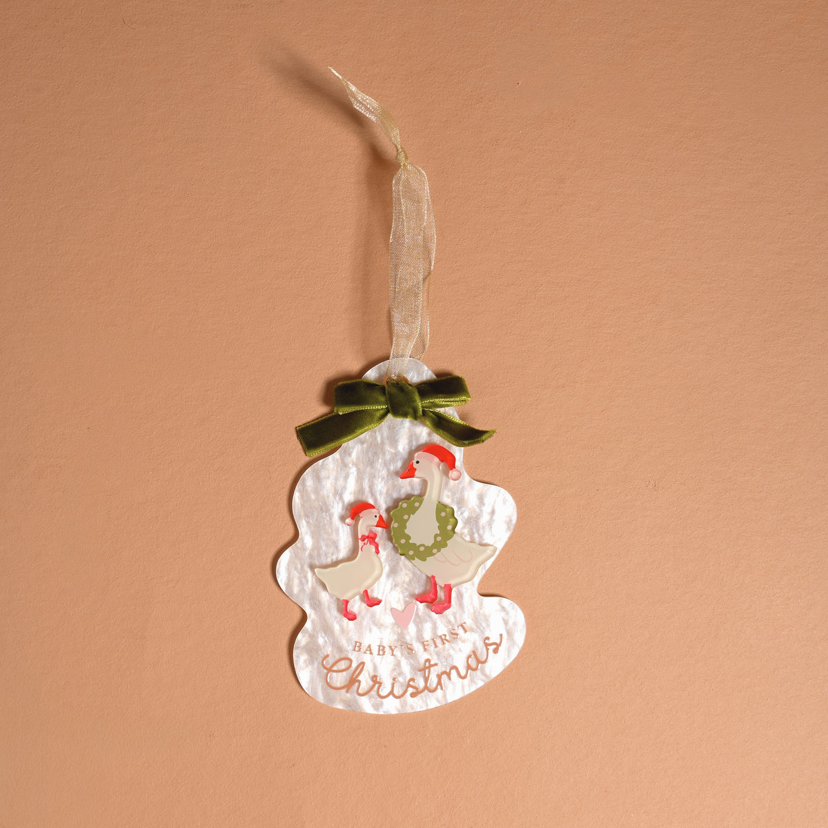 Baby’s First Christmas 2026 Acrylic Ornament featuring two illustrated geese, a green bow, and the text Baby’s First Christmas on an irregularly shaped ornament.
