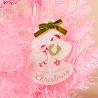 The Baby’s First Christmas 2026 Acrylic Ornament is a tree-shaped decoration featuring two geese in Santa hats and a wreath, hanging on a pink holiday styling tree.