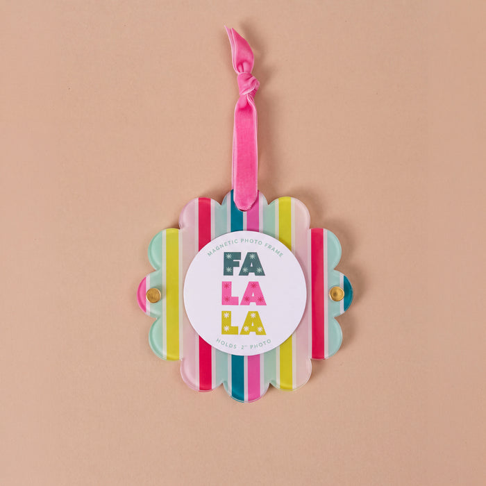 Fa La La Scalloped Round Picture Frame Ornament featuring a scalloped round frame with vertical multi-colored stripes, a pink hanging ribbon, and a central magnetic insert that reads Fa La La.
