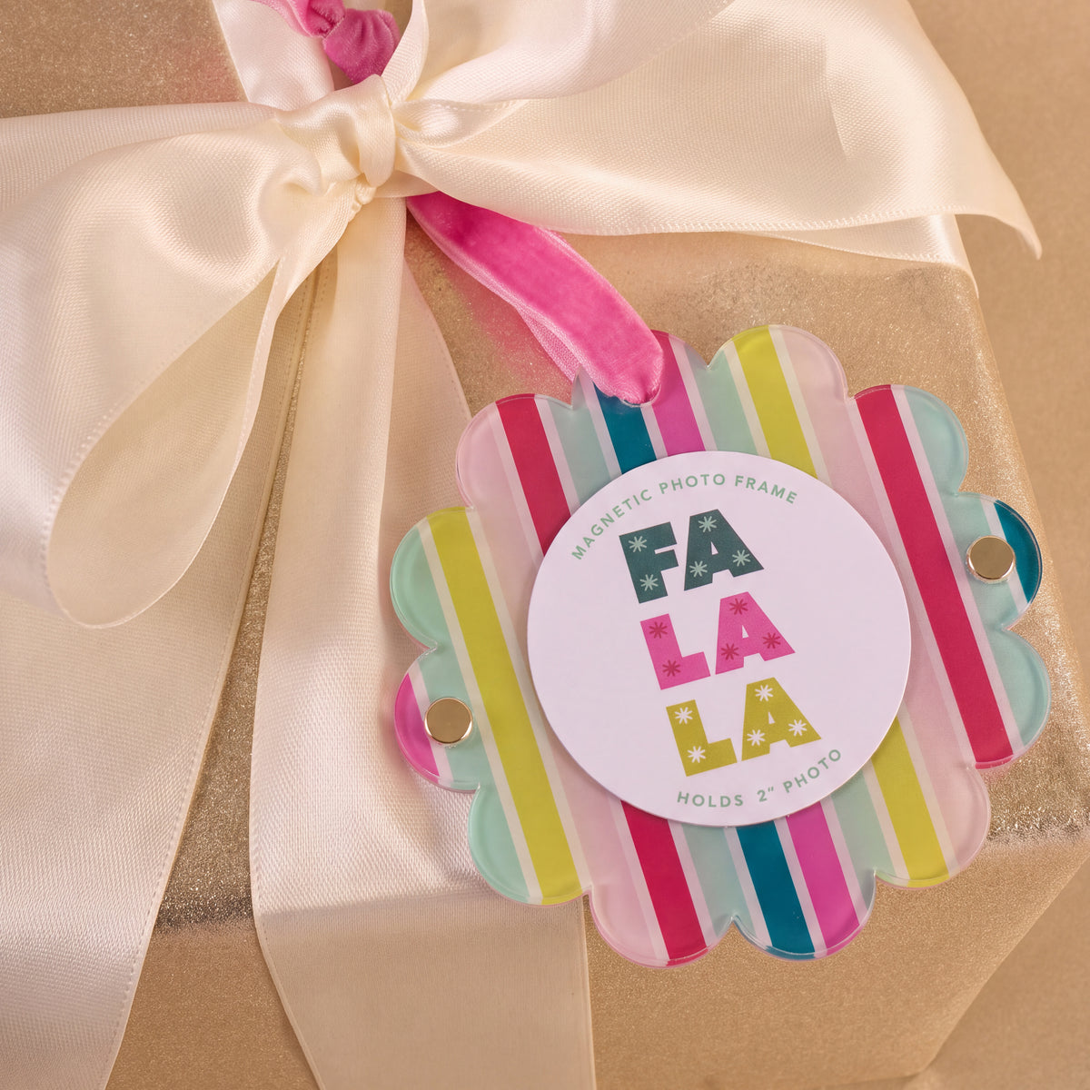 Fa La La Scalloped Round Picture Frame Ornament featuring a scalloped, multi-colored striped acrylic frame with a center white magnetic disc labeled FA LA LA.