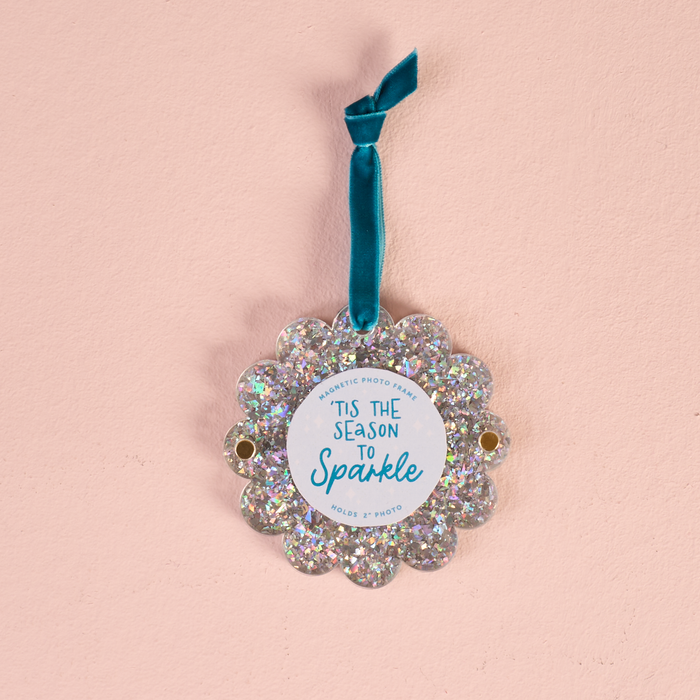 The Darling Effect Silver Glitter Scalloped Round Picture Frame Ornament features a teal velvet ribbon, the text Tis the season to sparkle, and holds a 2-inch photo.