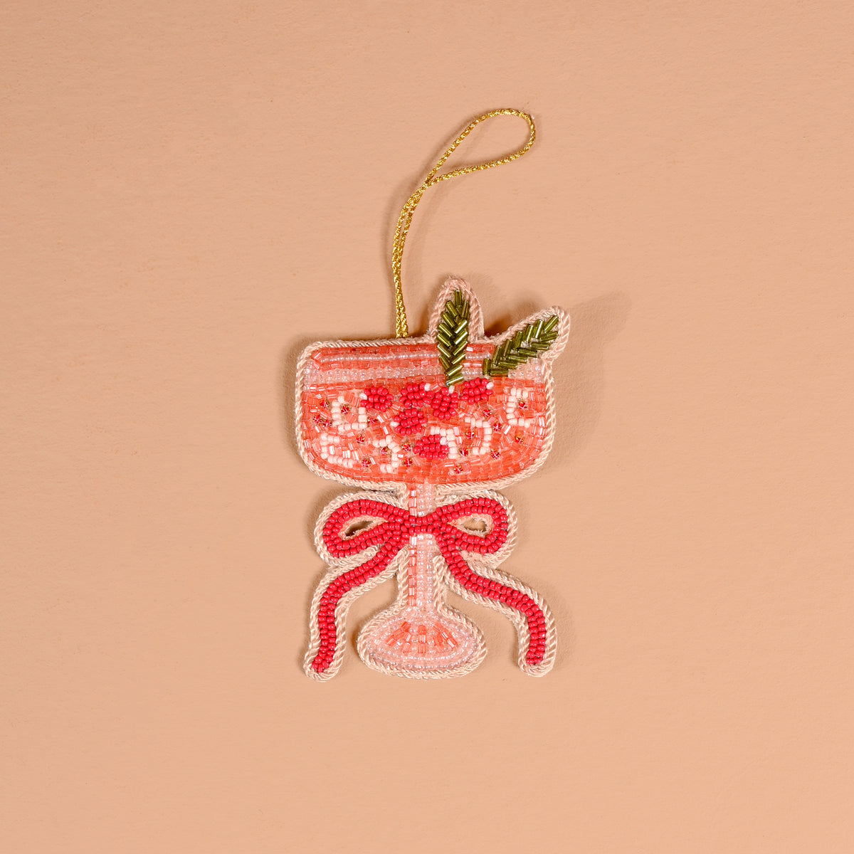 Cranberry Cosmo Handcrafted Beaded Ornament shaped like a cocktail glass filled with pink liquid, garnished with green leaves and a red bow.