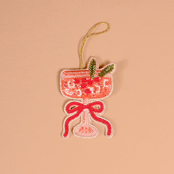 Cranberry Cosmo Handcrafted Beaded Ornament shaped like a cocktail glass filled with pink liquid, garnished with green leaves and a red bow.