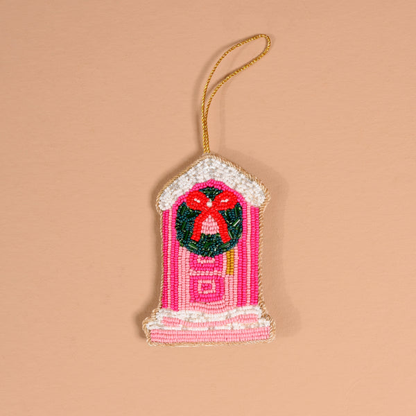 Darling Doorstep Handcrafted Beaded Ornament in the shape of a pink front door with a green wreath and a red bow.
