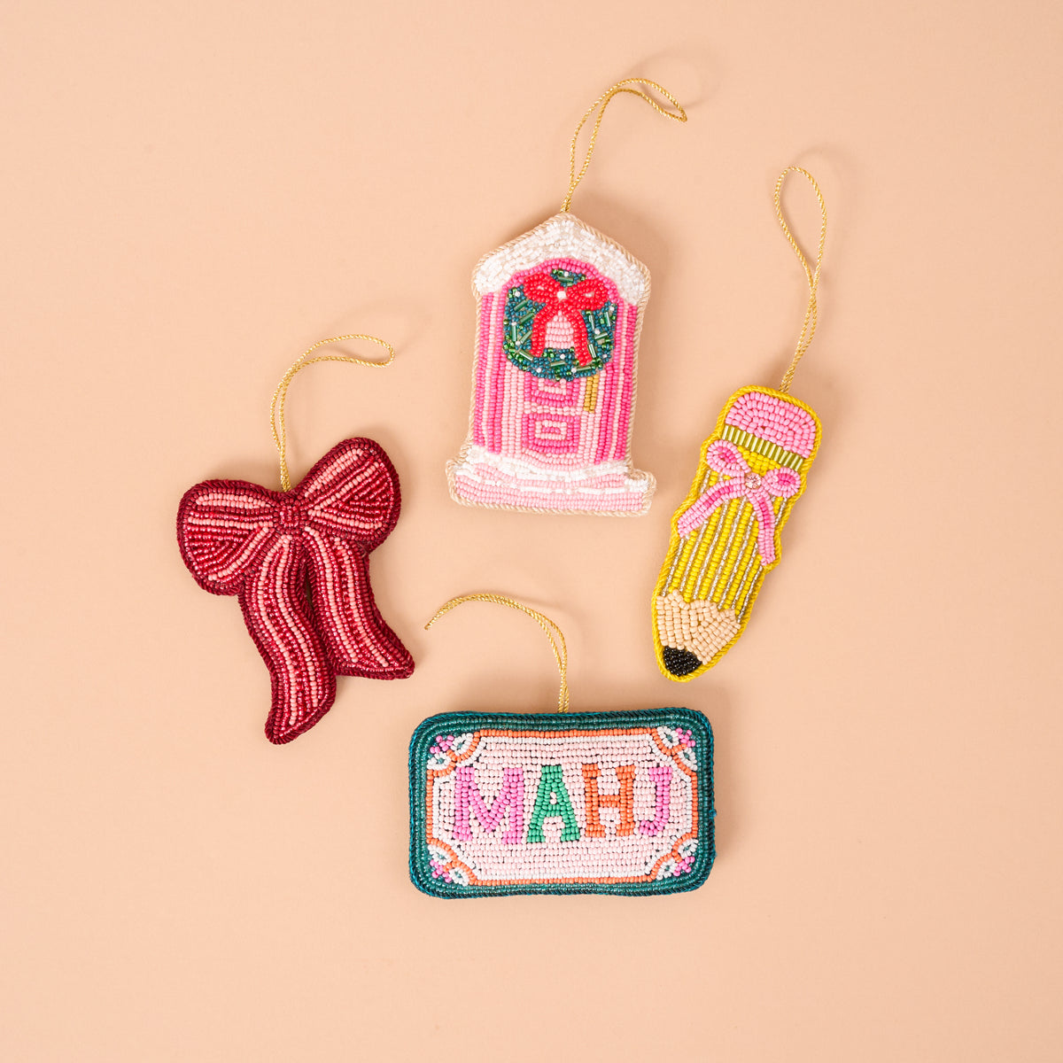 Four handcrafted beaded ornaments: a Red Bow Handcrafted Beaded Ornament, a pink door with a wreath, a yellow pencil, and a rectangular sign reading MAHJ.