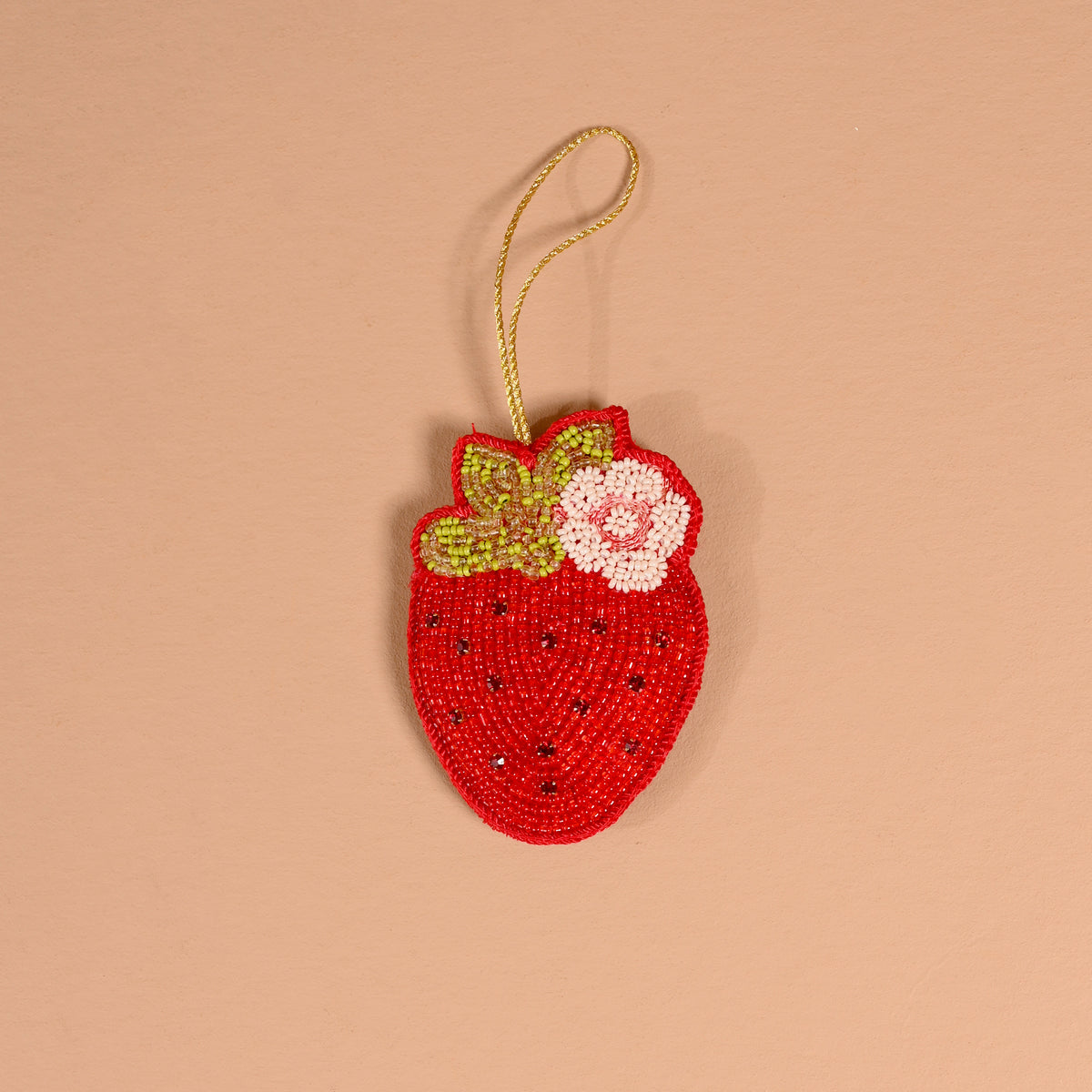 A Strawberry Handcrafted Beaded Ornament shaped like a strawberry, featuring red, green, and white beads with a gold hanging loop.