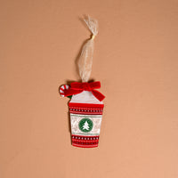 Peppermint Latte Acrylic Ornament shaped like a coffee cup with a red bow, a peppermint candy charm, and a circular logo featuring a Christmas tree, perfect for holiday styling.