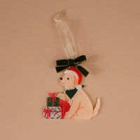 Santa Paws Acrylic Ornament featuring a light-colored puppy in a Santa hat and green bandana, sitting by two wrapped gifts and topped with a dark green velvet bow.