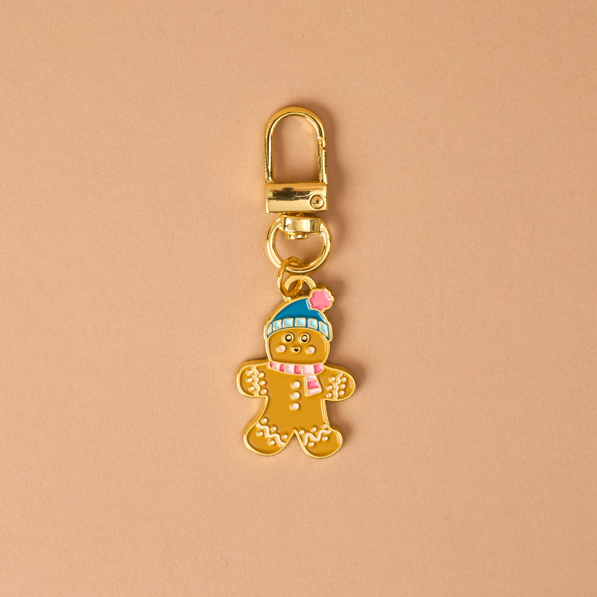 Gingerbread Pawfect Collar Charm: a gold-toned metal gingerbread person wearing a blue hat and pink scarf, attached to a lobster clasp for pet collars.